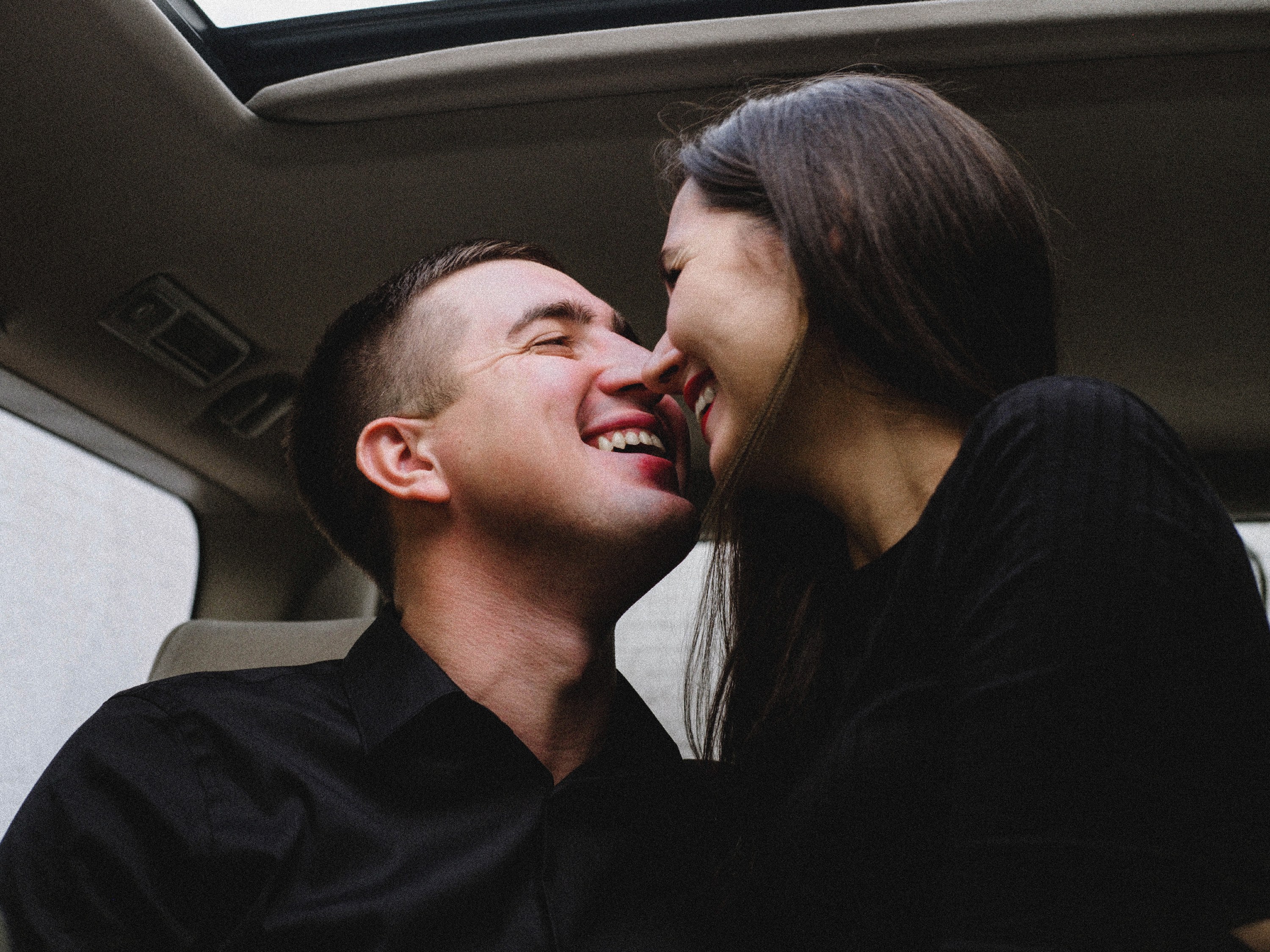 Man and woman kissing in car