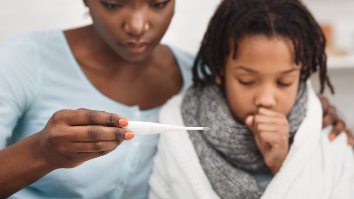 Cold Symptoms. Worried mother looking at thermometer, ill daughter coughing.